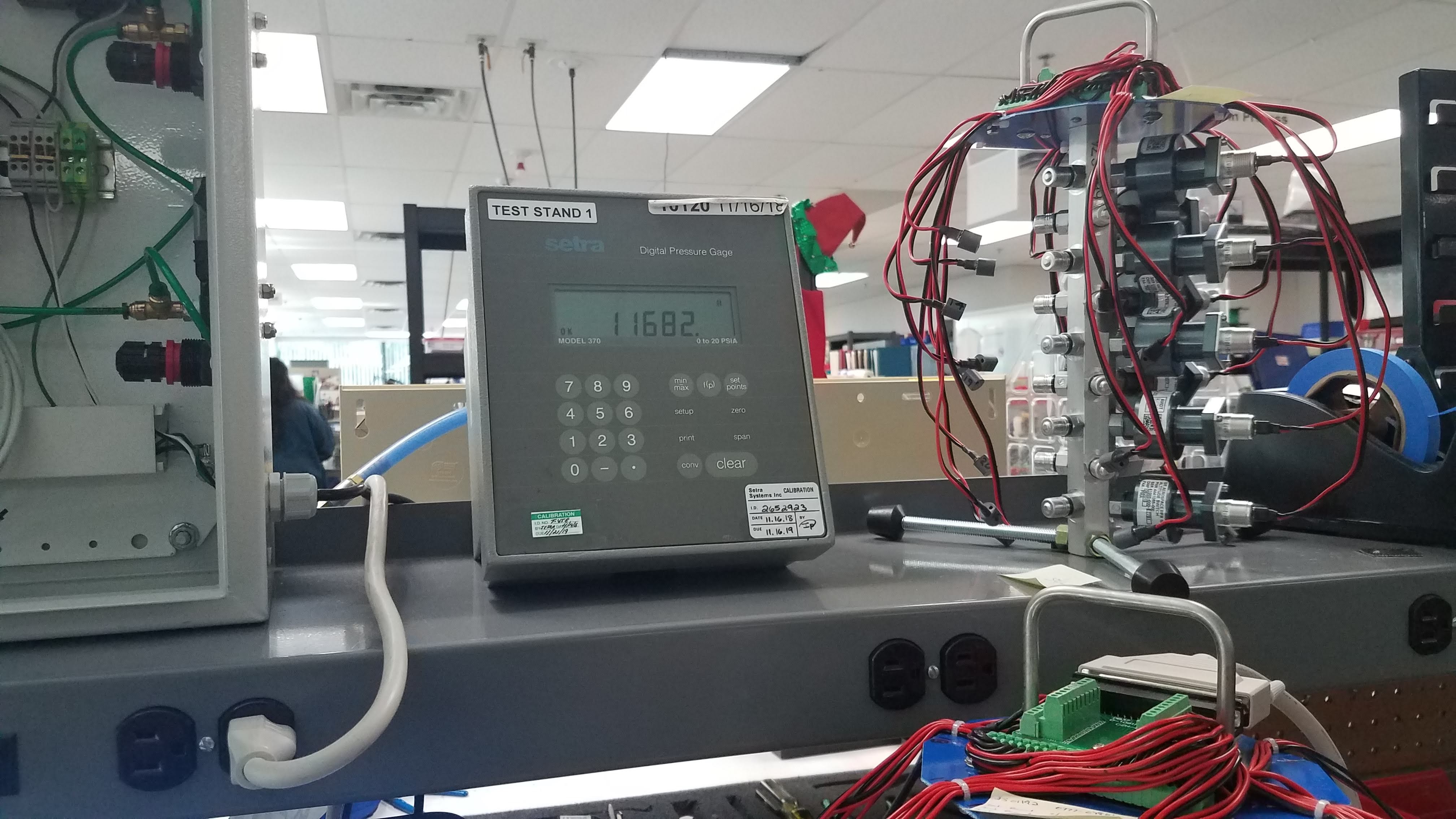 Pressure gauge and switch test fixture connected during altitude simulation